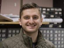 A young white man with short sandy hair smiles